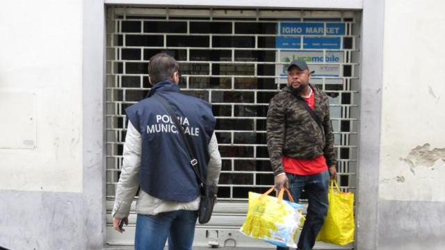 Il gestore del phone center mentre lascia il negozio (foto Batavia)