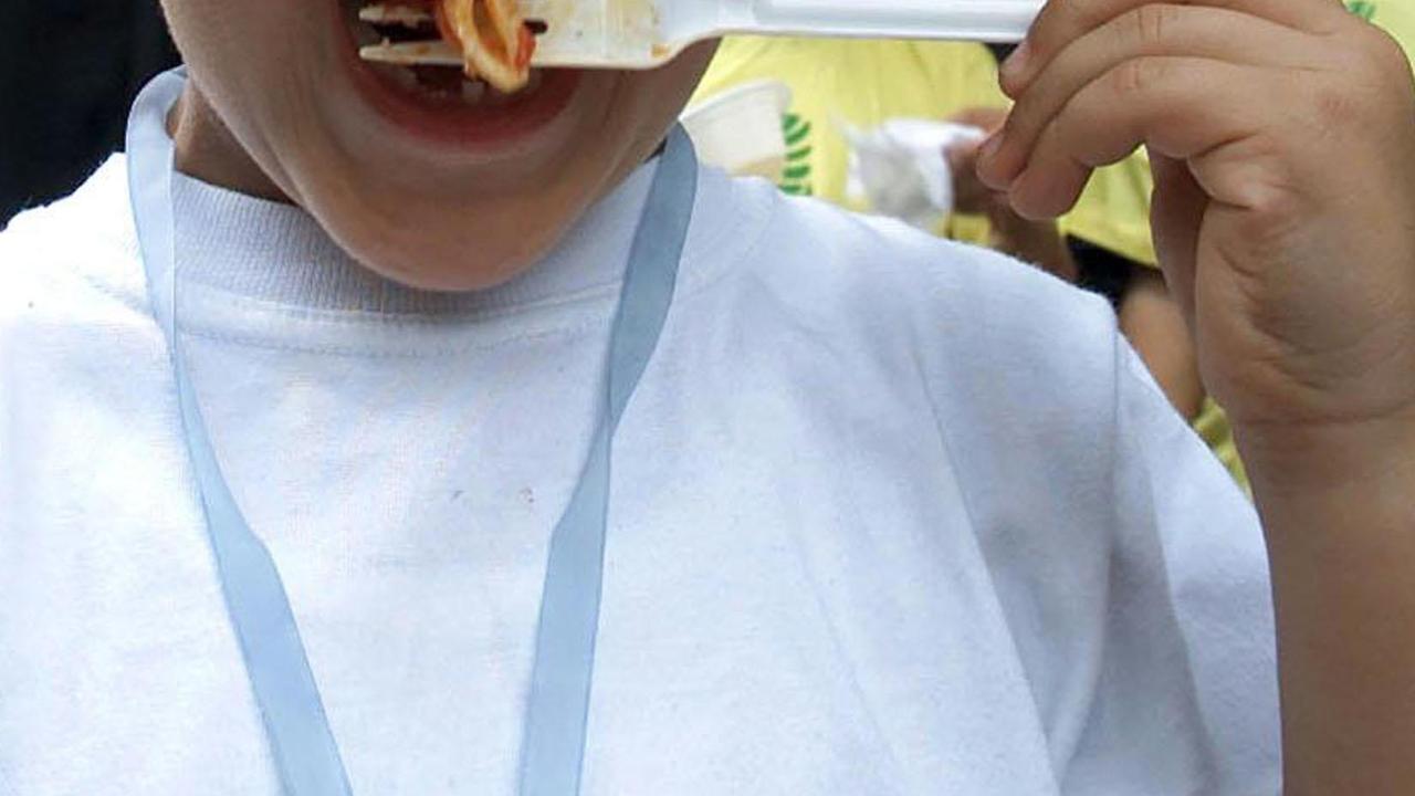 Un bambino con la pasta al pomodoro