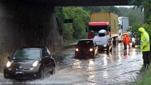 Auto in transito su una strada allagata (Pentafoto)