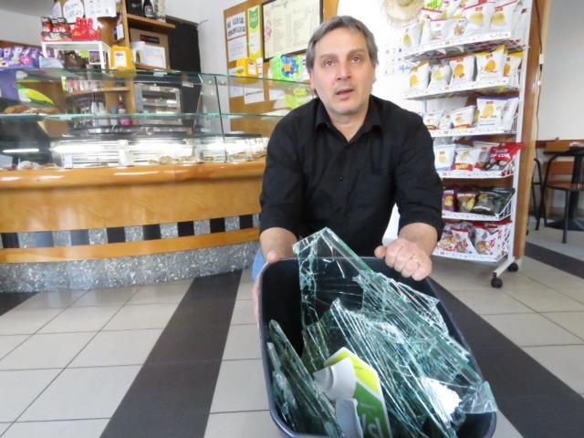 Il titolare del bar Alessandro Gaito con i pezzi della vetrata (foto Batavia)