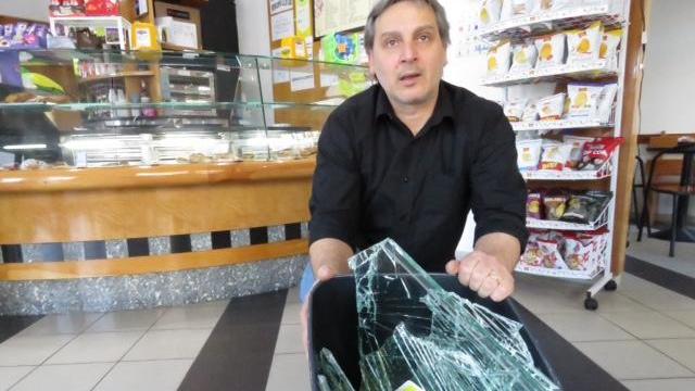 Il titolare del bar Alessandro Gaito con i pezzi della vetrata (foto Batavia)