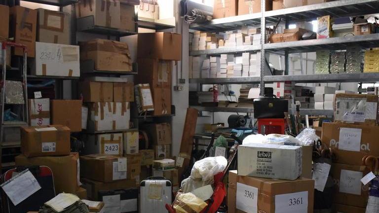 Scaffali colmi di scatoloni nel deposito di via Civitella Paganico 2 a Grosseto (foto Agenzia Bf)