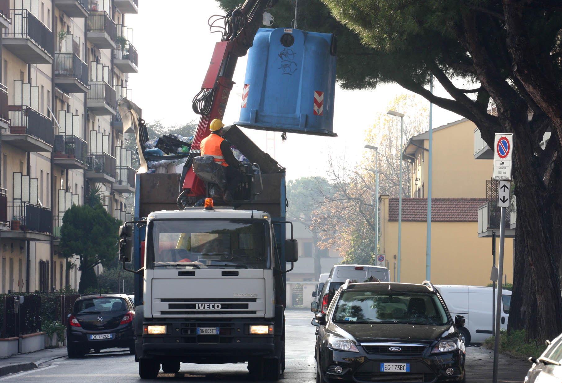 Un camion che svuota una campana del vetro