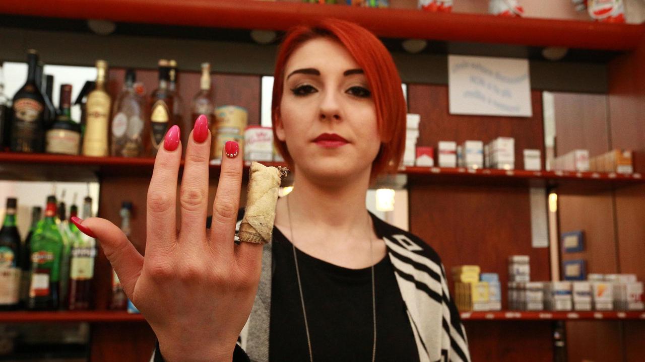 La ragazza aggredita che mostra la ferita a un dito (foto agenzia Sestini)