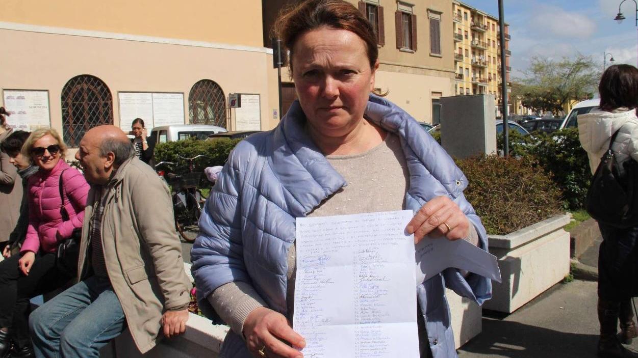 Una delle protagoniste del presidio mostra la petizione firmata dai frequentatori delle biblioteche in solidarietà con i lavoratori (Repetti Pentafoto)