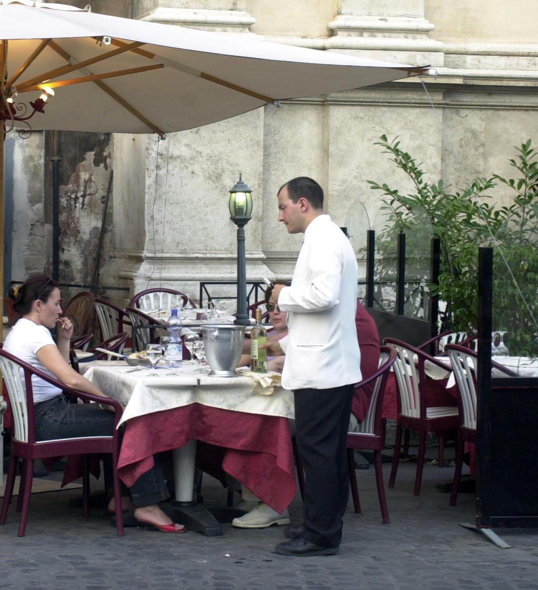 Un cameriere serve ai tavoli (foto d'archivio)