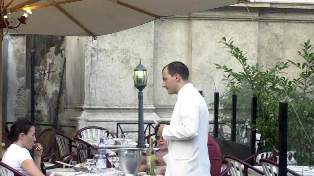 Un cameriere serve ai tavoli (foto d'archivio)