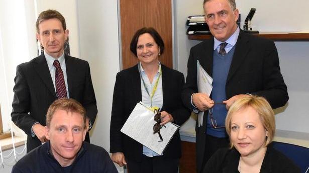Martina Raffaelli (prima da destra), specialista del servizio Spid dell’ufficio postale di Grosseto centro, con il neoutente Spid, Matteo Seccia (seduto accanto a lei). In alto a destra il direttore della filiale Alfonso La Cava
(foto Bf)