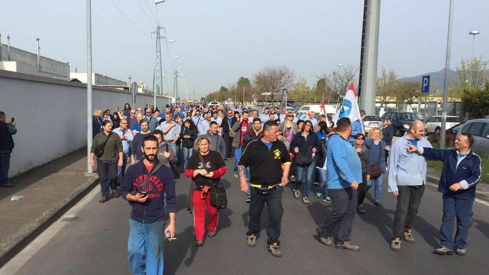 Le tute blu incrociano le braccia