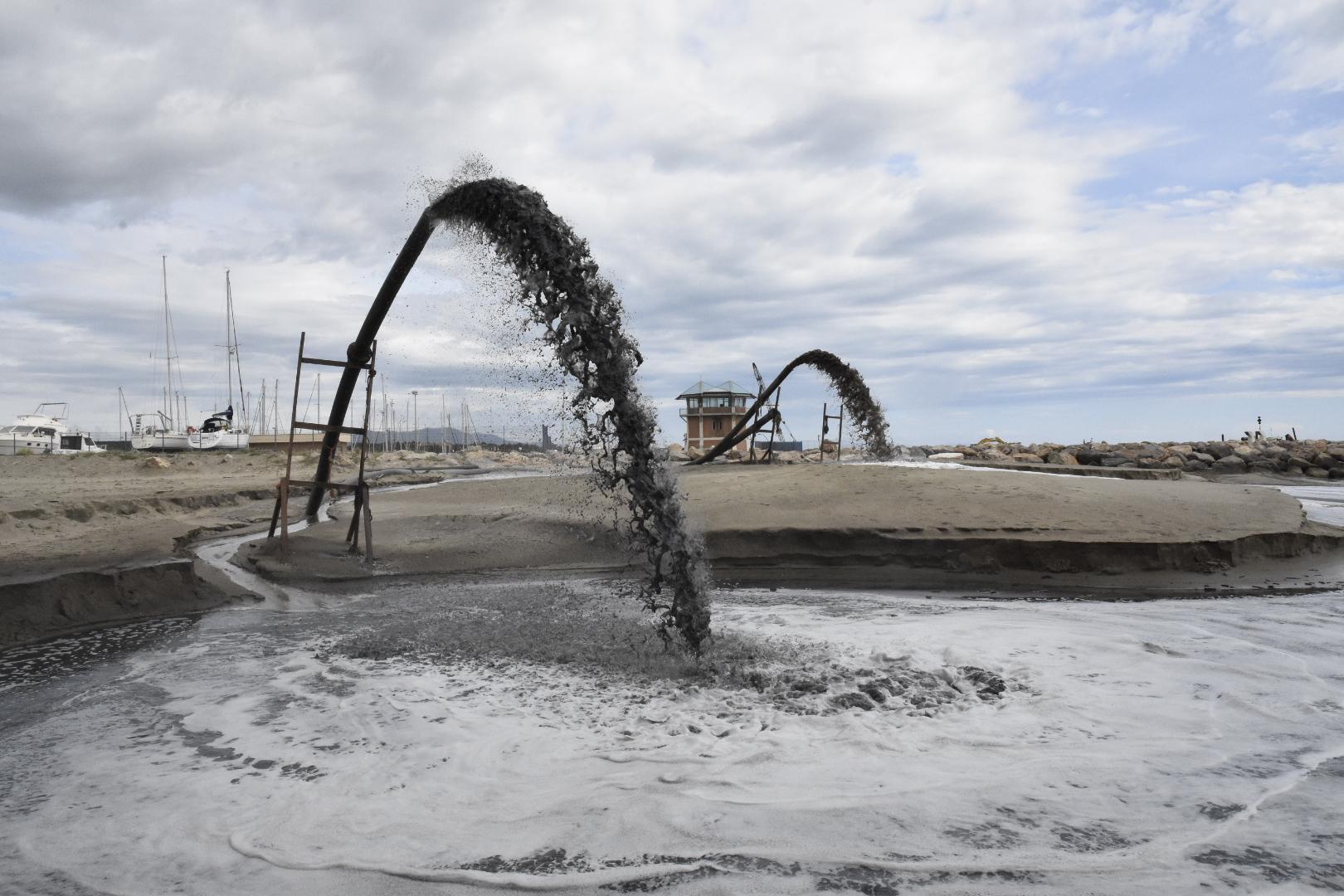 Le idrovore della Marina di San Rocco al lavoro. In primo piano quella che pesca la sabbia dall'avamporto. In secondo piano quella che la preleva dal mare sul lato sud del porto (foto Bf)