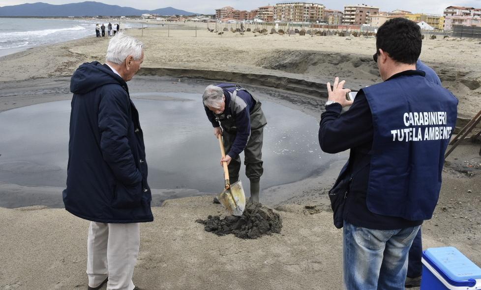 Un tecnico dell'Arpat effettua il prelievo di sabbia davanti a una delle due idrovore di Marina di Grosseto, sotto gli occhi di Felice Serra e di un carabiniere del corpo di tutela ambientale (foto Agenzia Bf)