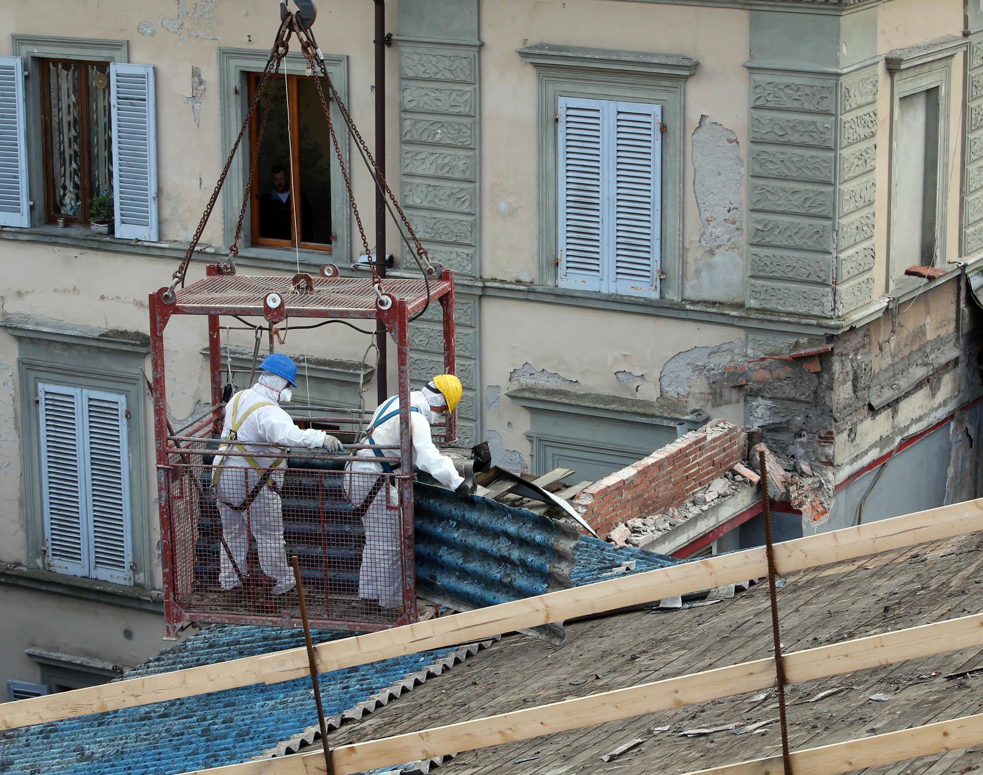 Operai al lavoro dopo il crollo del tetto dell'ex cinema Adriano (foto Nucci)