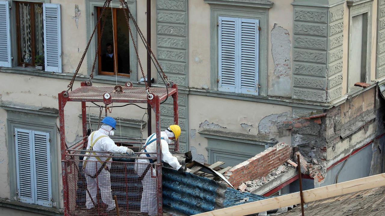 Operai al lavoro dopo il crollo del tetto dell'ex cinema Adriano (foto Nucci)