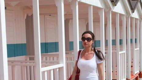 Turista a passeggio lungo le tipiche cabine parallele al mare a Forte dei Marmi