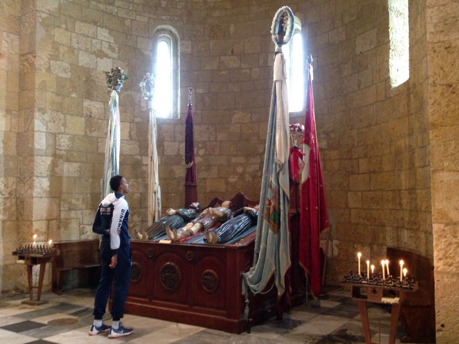 Il giocatore della Dinamo Kenny Kadji si sofferma davanti alle statue dei martiri turritani nella basilica di San Gavino