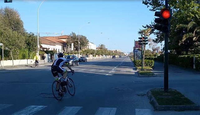 Un ciclista passa col rosso sul viale a mare a Forte dei Marmi (dal video Ciurca / Paglianti)