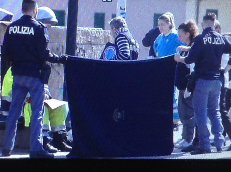 La polizia sorregge il telo che nasconde il corpo del ragazzo (foto Batavai) 