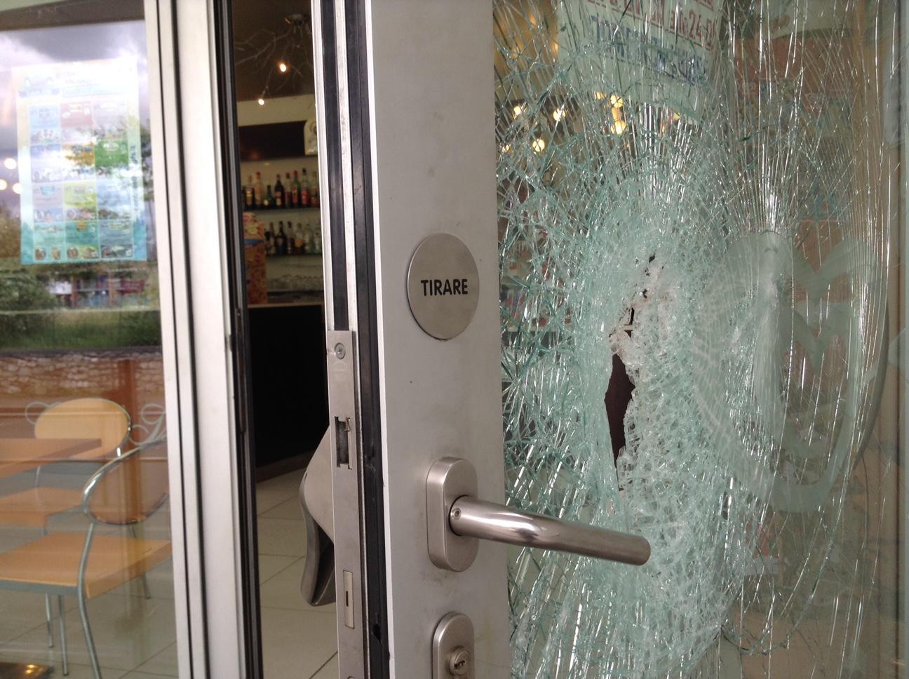 La porta danneggiata al bar della Misericordia (foto Batavia)