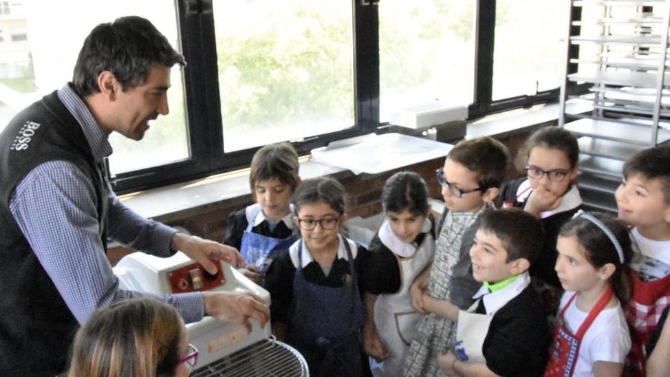 Venti bambini studiano e imparano come si fa il pane