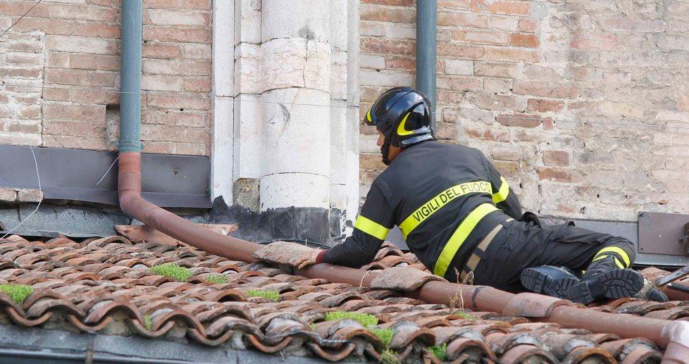 Un vigile del fuoco sulla tettoia dei portici del duomo di Ferrara