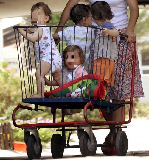 Bambini dentro un carrello della spesa (foto archivio)