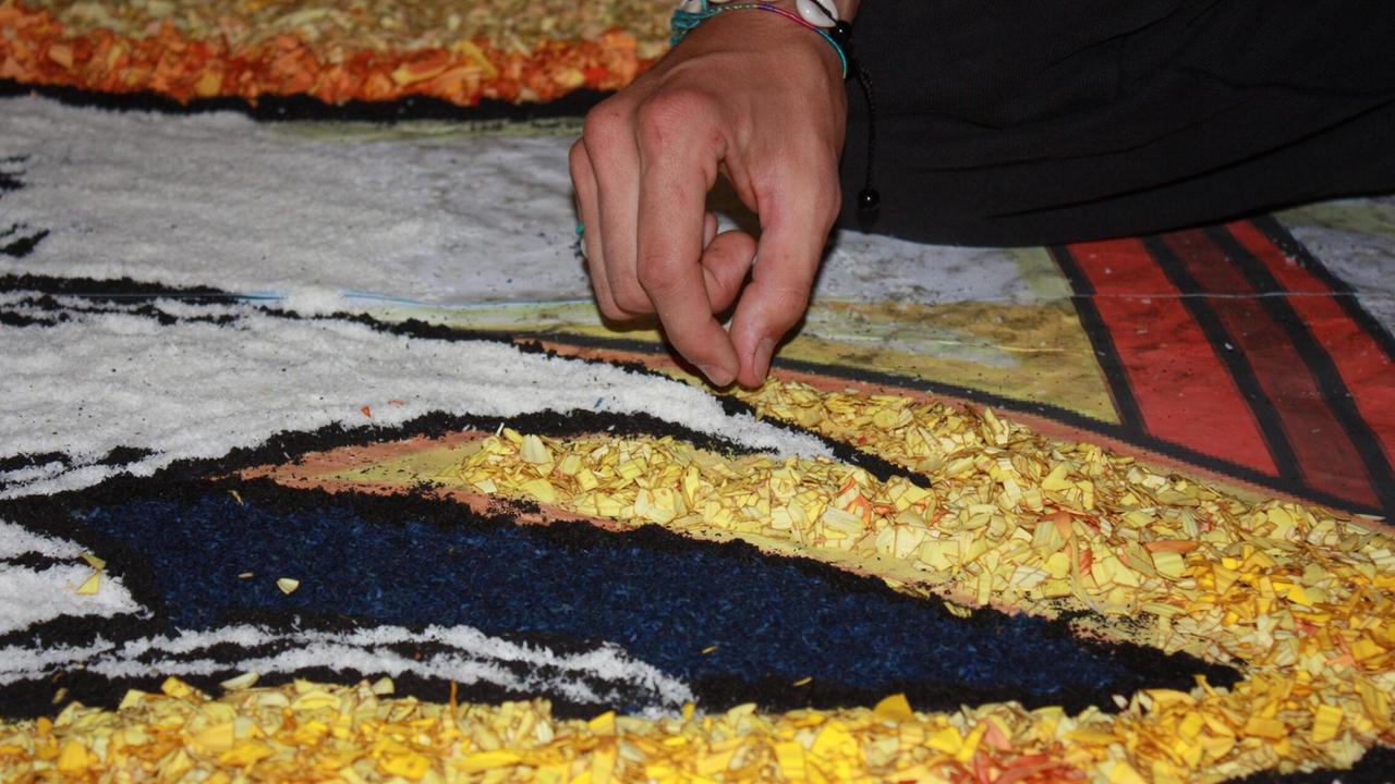 Un tappetaro al lavoro nella notte che precede il Corpus Domini