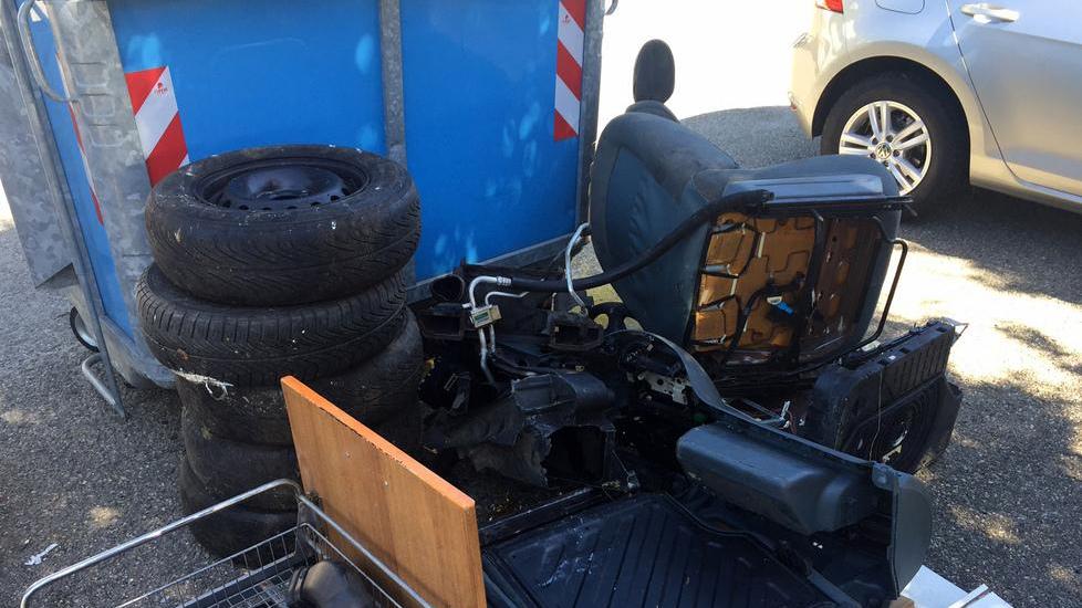 Mezza auto gettata vicino ai cassonetti dei rifiuti