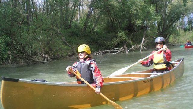 Una coppia pagaia lungo il fiume su una canoa