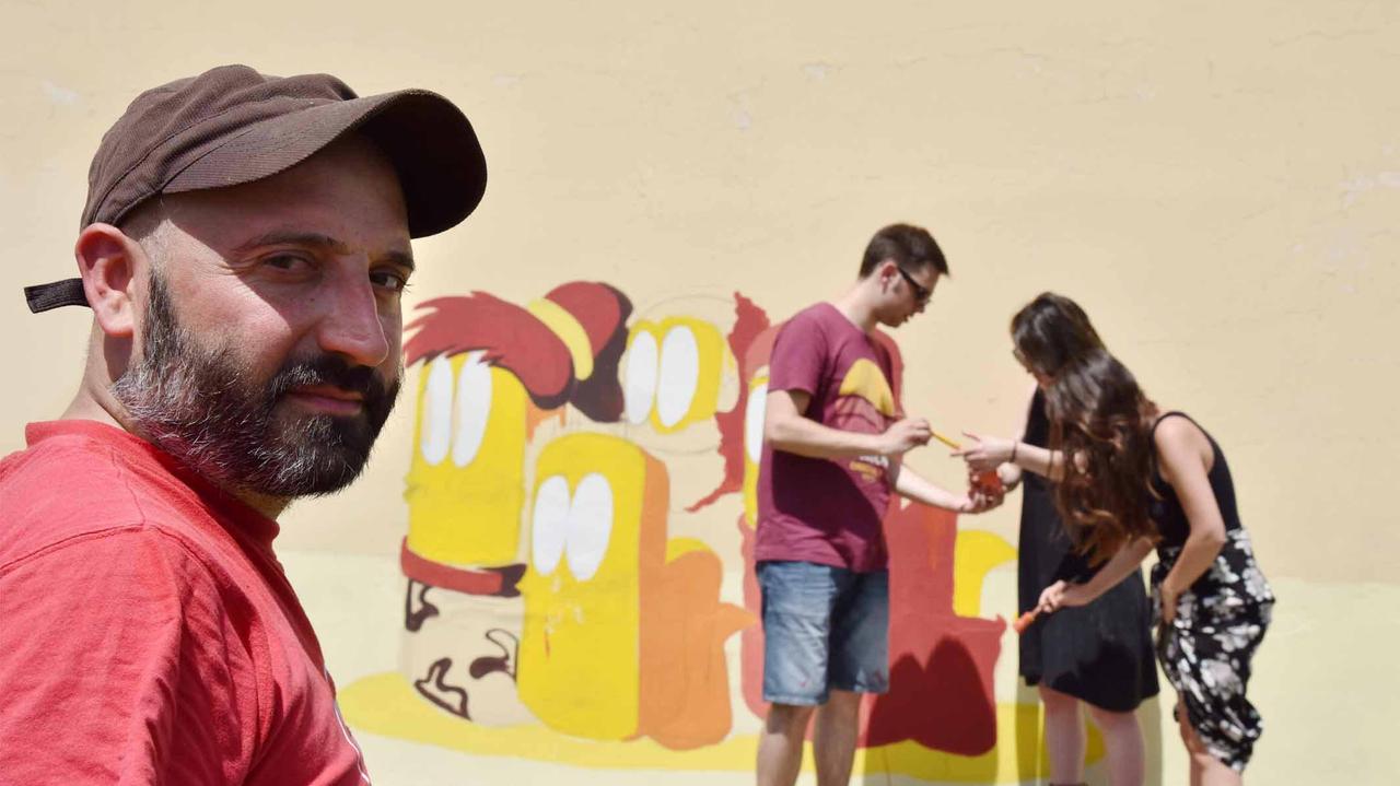 L’artista milanese Rouges impegnato nella realizzazione del murales (Foto Agenzia Carlo Sestini)