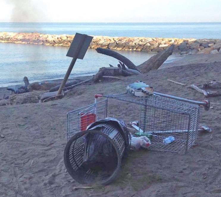 Il fuoco ancora acceso e i rifiuti lasciati in spiaggia dopo il bivacco notturno