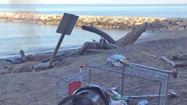 Il fuoco ancora acceso e i rifiuti lasciati in spiaggia dopo il bivacco notturno