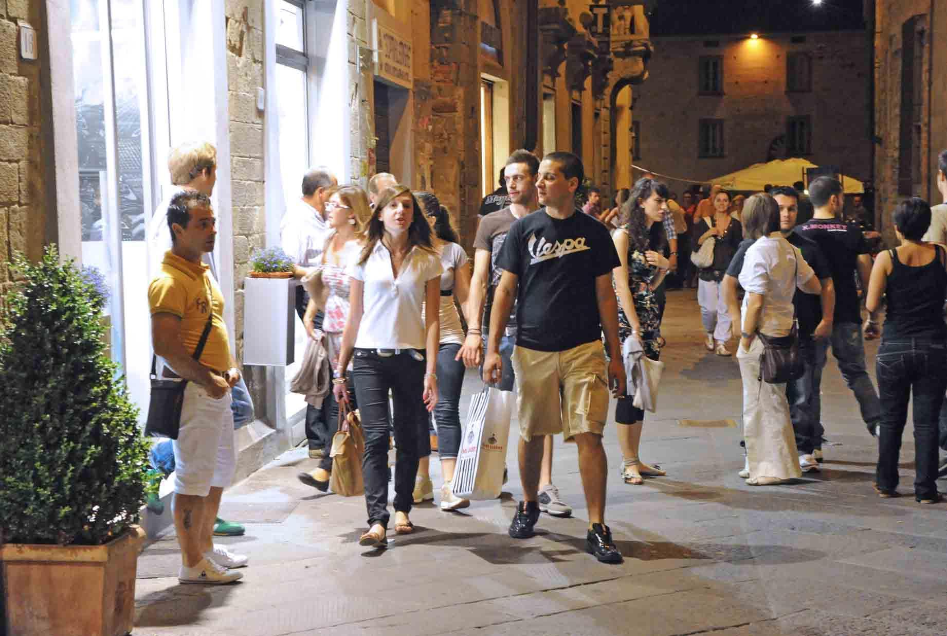 Persone a passeggio per le strade del centro durante i Percorsi notturni