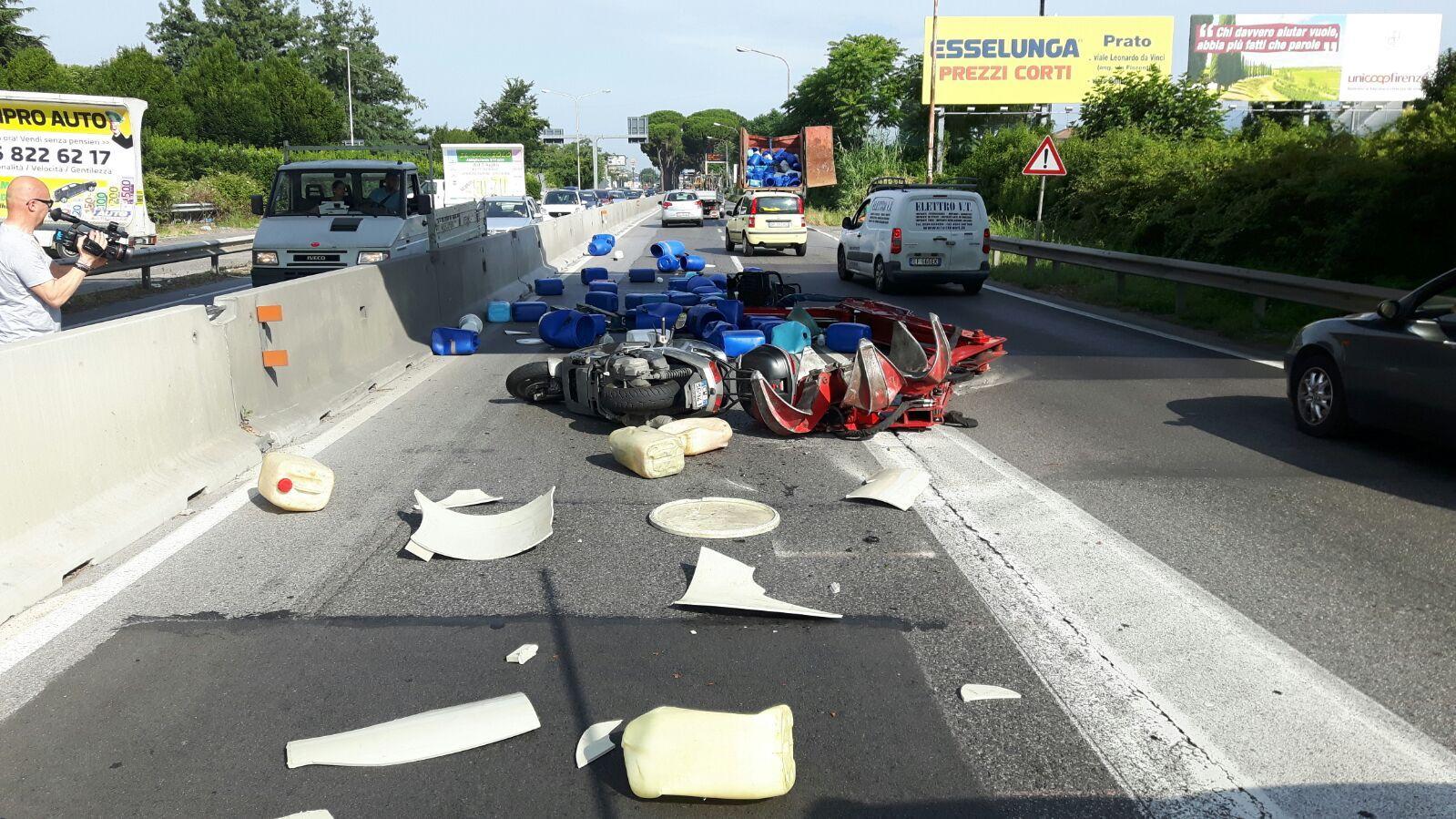 Il carico rotolato sulla carreggiata e la moto coinvolta nell'incidente (foto Batavia)