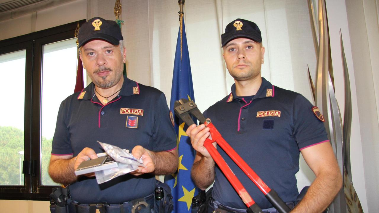 Due poliziotti con le tronchesi utilizzate nel furto (foto Batavia)