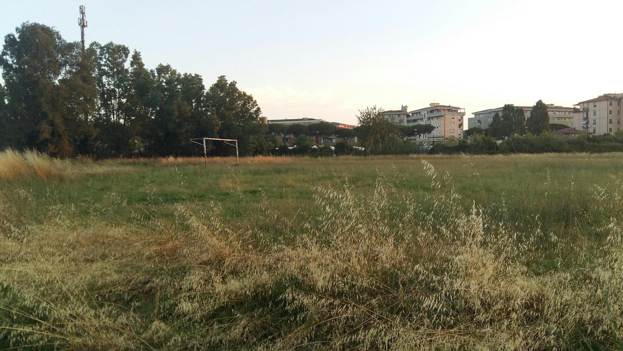 L’incuria del campo di calcio e sullo sfondo i palazzi del quartiere