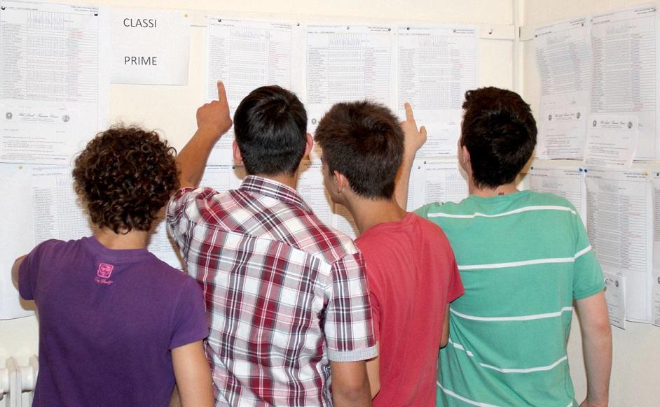 Un gruppo di studenti davanti ai tabelloni degli scrutini di una scuola superiore