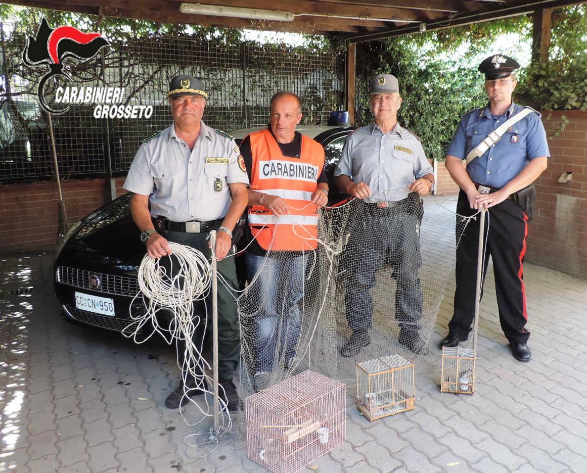 I carabinieri e le guardie del Nucleo operativo zoofilo con la rete trovata a casa del 36enne e le gabbie con i cardellini