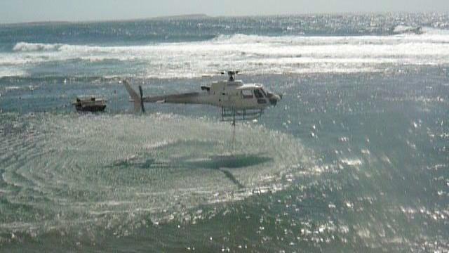 Un elicottero fa rifornimento di acqua in mare