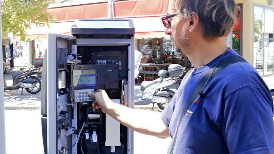 Un tecnico al lavoro per l'adeguamento del parchimetro di piazza Damiano Chiesa alla modalità pagobancomat (foto Marzi Pentafoto)