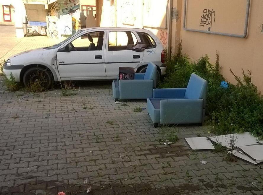 Cimitero di auto e rifiuti al centro commerciale 