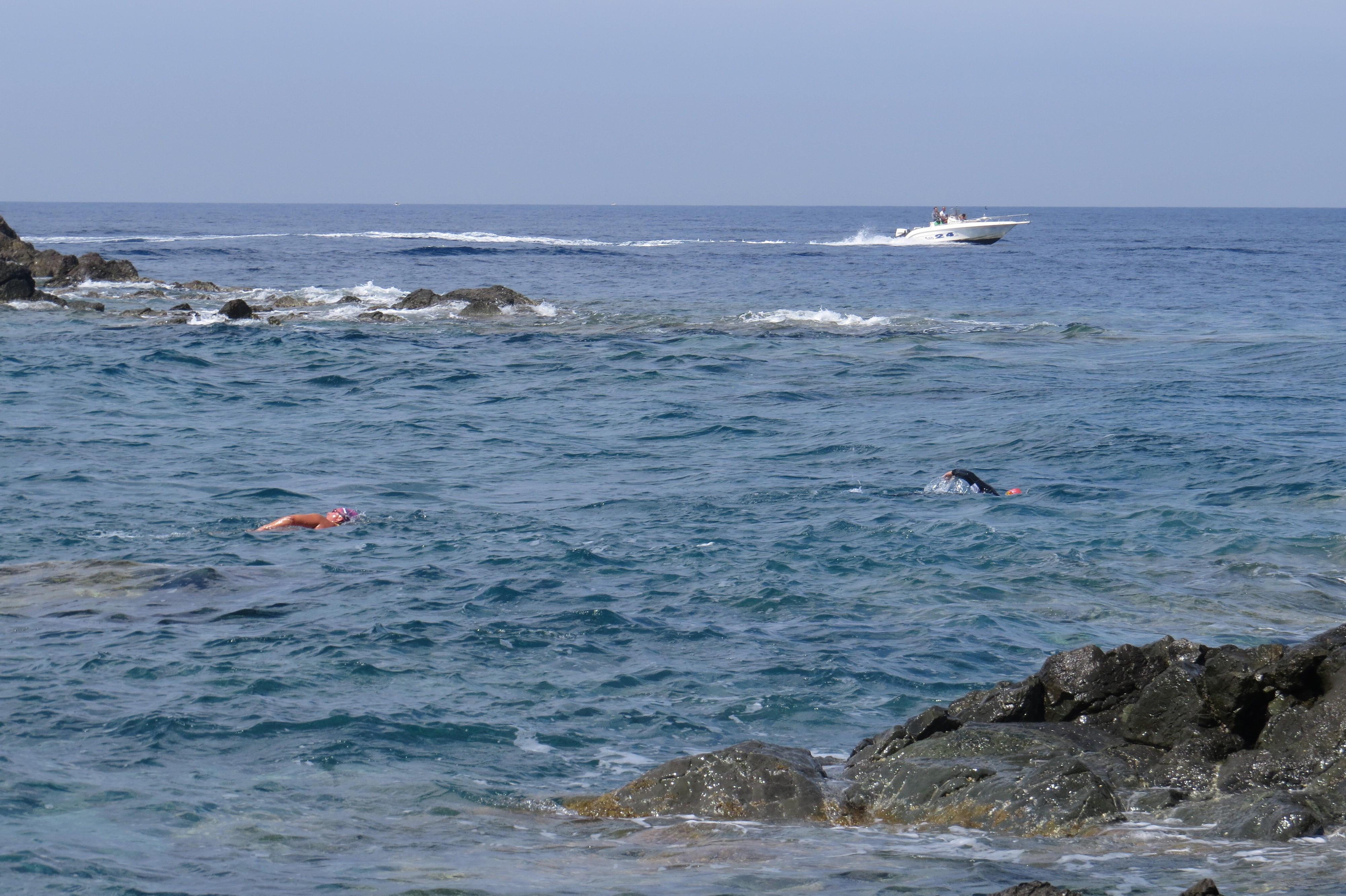 La barca che sfreccia nell’area vietata, sono i nuotatori che si fermano per farla passare