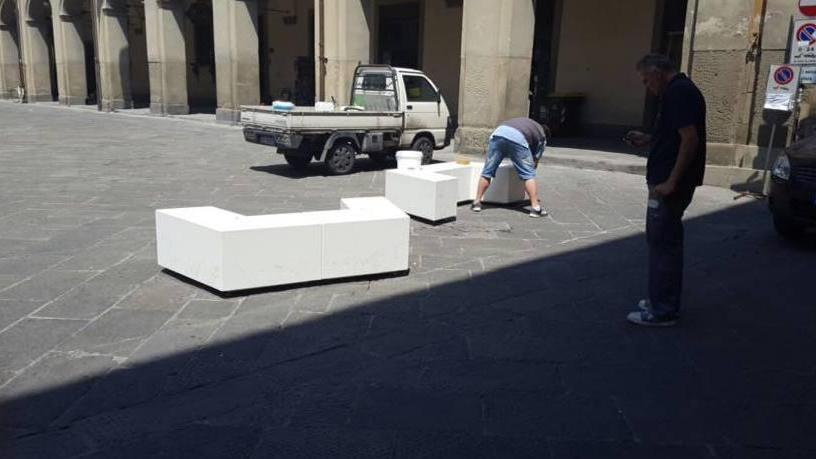 Le panchine vengono ripulite dallo sporco in piazza del Comune