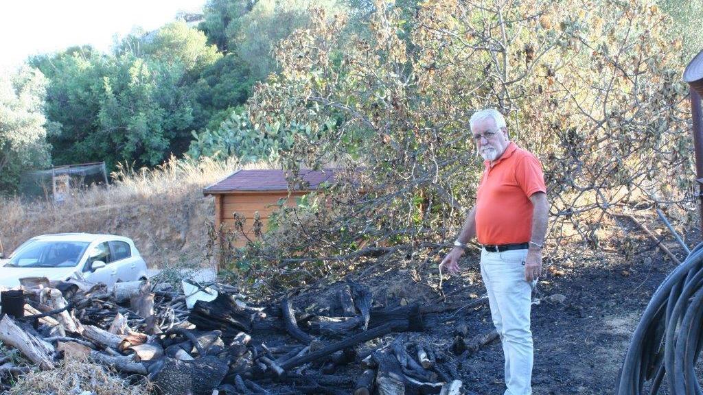 Quintino Sollai davanti alla legnaia bruciata