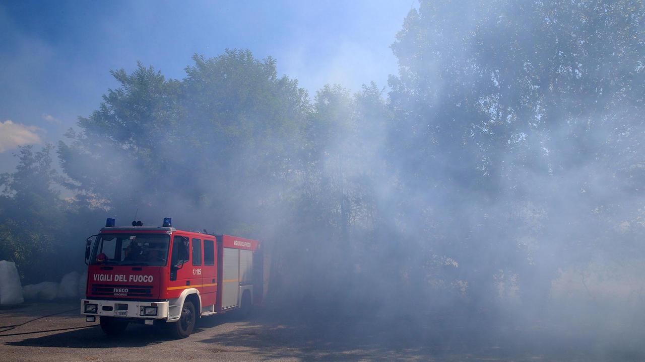 Il mezzo dei pompieri avvolto dal fumo denso dell'incendio (foto Nucci)