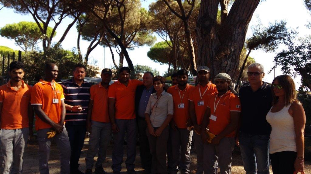 Il gruppo di migranti di Uscita di sicurezza al Vivaio Principina. Al centro il sindaco di Grosseto, Antonfrancesco Vivarelli Colonna, e la titolare del vivaio, Loretta Teresini