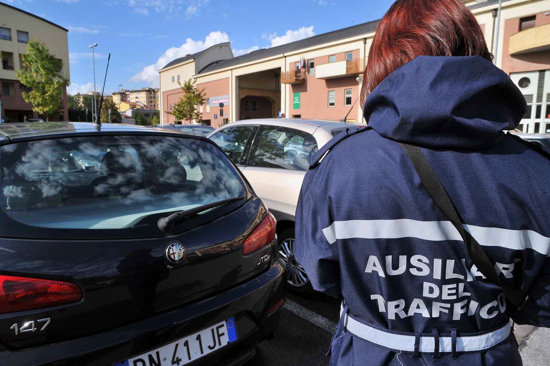 Ausiliare del traffico impegnata al controllo alle auto in sosta