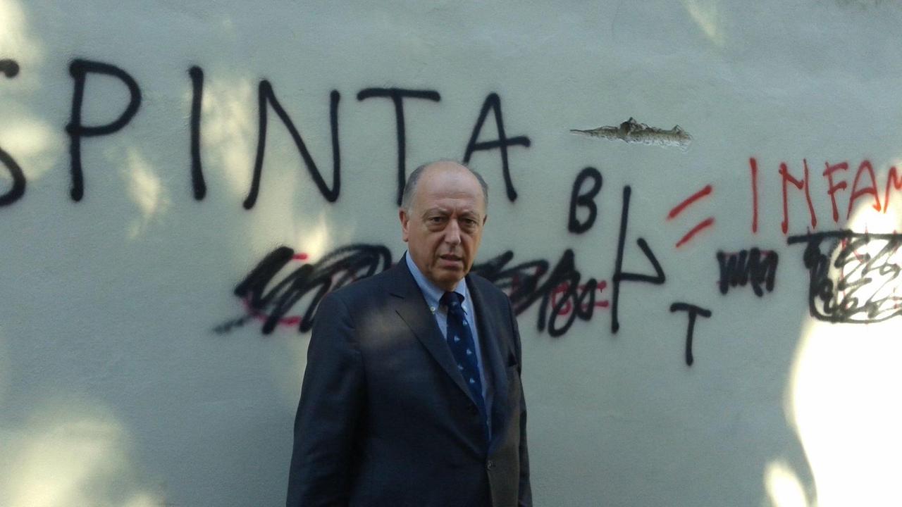 Tambellini di fronte ai muri imbrattati