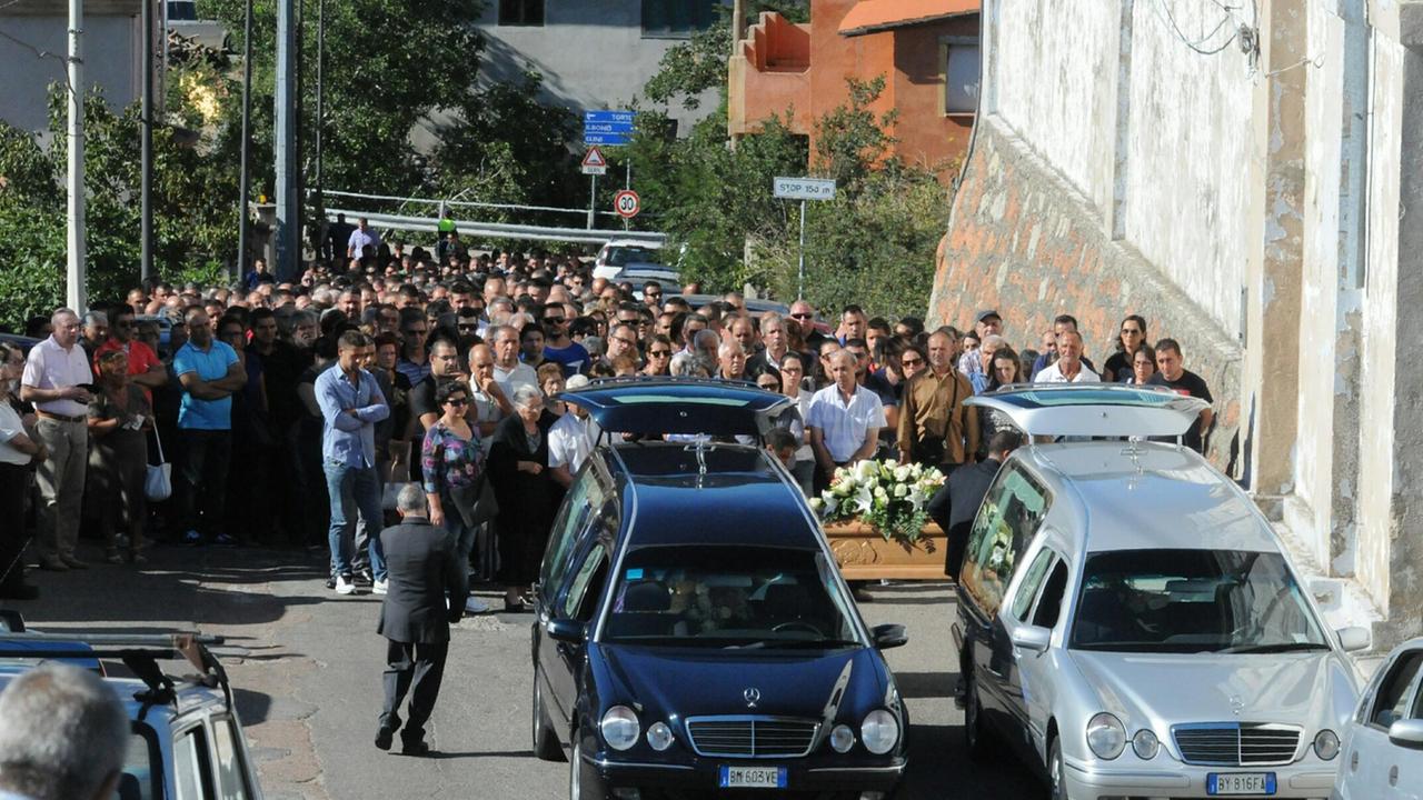 La folla accompagna i due carri funebri