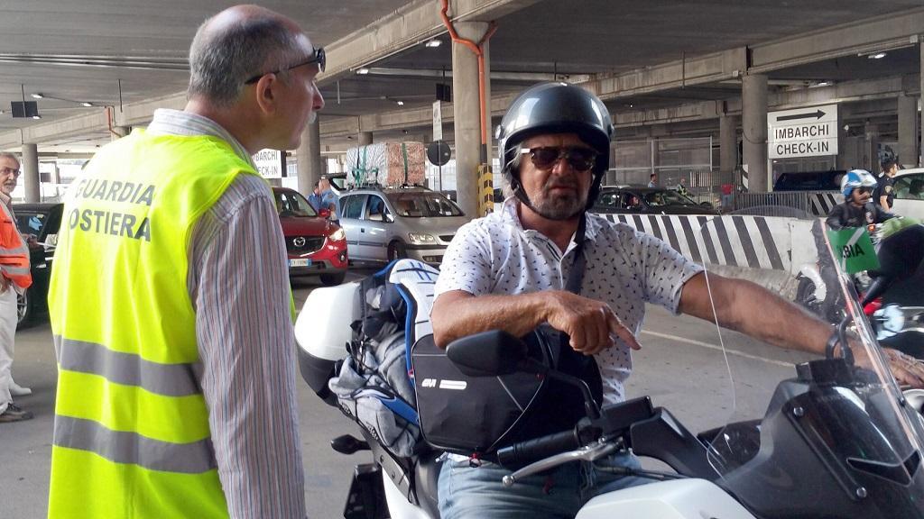 Beppe Grillo sul suo scooter ai controlli di sicurezza prima di salire sul traghetto Genova-Olbia