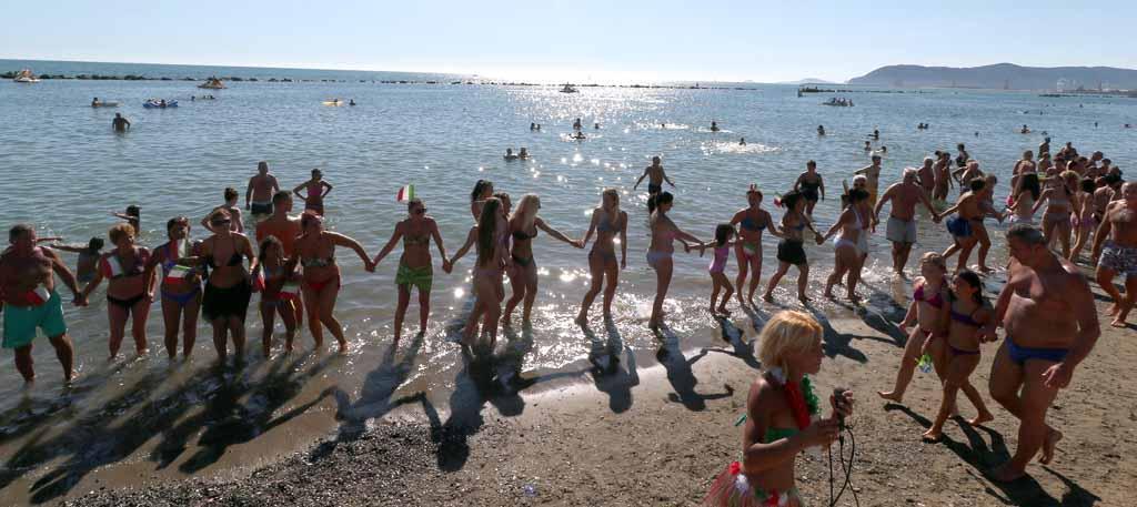 Una catena umana col tricolore in spiaggia